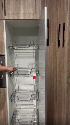 a person is opening the door to an empty pantry