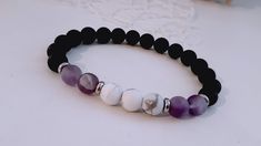 Beautiful handcrafted stretch Bracelet, Boho style, with 8 mm opaque of lavender Amethysts, opaque black Onyx, opaque white Howlite, with stainless steel elements that are totally hypoallergenic and never change the color.  They are mounted on silicone elastic threads of greater resistance.  It's Unisex, a perfect gift for someone special and stylish.  Quite adjustable size but for a better realization of the article please choose the right wrist size from the table, if not, I will send you the Handmade White Amethyst Bracelets, White Stone Bracelet, Energy Protection, Howlite Bracelet, Meditation Bracelet, Elastic Thread, Yoga Bracelet, White Howlite, Yoga Gifts