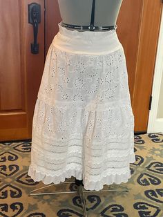 This handmade white eyelet and lace skirt, is fully lined. It has tiered rows of eyelet and lace trim to keep a delicate soft flow. It fits a 6 to 8, the waist has a soft cotton knit waistband with shirred ruching for a better fit. The waist fits 28" to 34", the hip is 36", the length is 30" long. It has pockets. White Tiered Bottoms With Lace Trim, White Delicate Lace Skirt For Summer, White Tiered Cotton Skirt, Flowy Tiered Lace Skirt, Cotton Tiered Skirt With Lace Trim, Tiered Cotton Skirt With Lace Trim, Spring Tiered Skirt With Crochet Trim, Spring Tiered Skirt With Broderie Anglaise, White Eyelet Mini Skirt Outfit