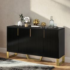 a black and gold sideboard sitting on top of a wooden floor next to a window