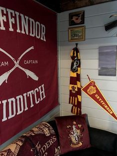 there are two harry potter banners hanging on the wall next to couches and pillows