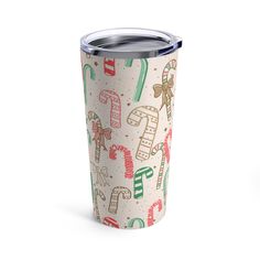 a christmas themed tumbler cup on a white background with candy canes and candies