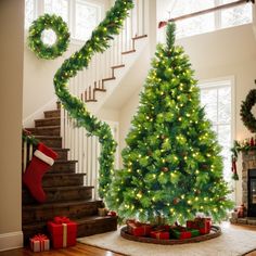 a decorated christmas tree sitting in the middle of a living room next to a staircase