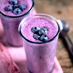 a smoothie with blueberries and oranges in the background