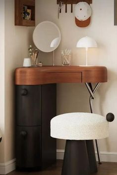 a white stool sitting under a mirror next to a desk with a lamp on it