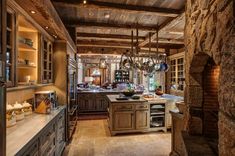 a large kitchen with stone walls and wooden cabinets