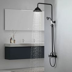 a shower head with water running from it's side in a bathroom area next to a sink and mirror