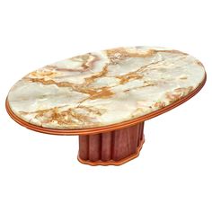 an oval marble table with copper trimmings on the top and bottom, against a white background