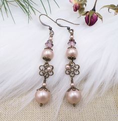 Handcrafted right in my own Wisconsin USA studio - these earrings feature top of the line elements including name brand crystal cored pearls in Champagne Powder Almond, along with Antique Pink almost plum colored matching crystals. The metals included are all antiqued brass filigree. The earrings hang almost 3 inches long including the brass ear wires. Thank you - shop my entire collection here: www.etsy.com/shop/hhjewelrydesigns Elegant Round Beads Crystal Earrings For Wedding, Elegant Beaded Crystal Earrings For Wedding, Vintage Wedding Accessories, Pink Crystal Earrings, Plum Color, Antique Pink, Long Dangle Earrings, Lovely Earrings, Pink Crystal