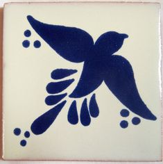 a blue and white tile with a bird on it's back side, in the shape of a square