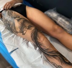 a woman laying on top of a bed covered in tattoos