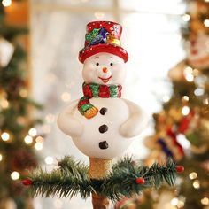 a snowman ornament hanging from a christmas tree