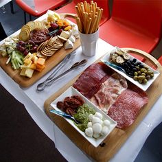 two trays filled with different types of food sitting on top of a white table