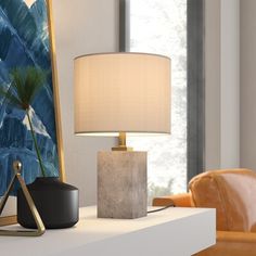 a table lamp sitting on top of a white counter next to a mirror and chair