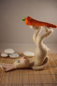 a stuffed animal holding a carrot on top of it's head in the air