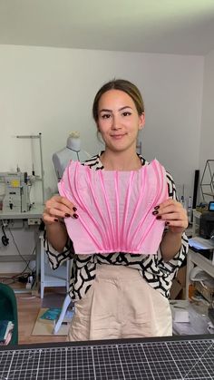 a woman holding a pink object in her hands