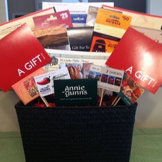 a black basket filled with lots of different types of cards and books on top of a table