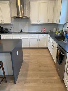 a kitchen with white cabinets and black counter tops