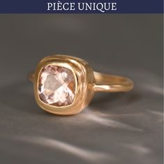 a gold ring with a pink stone in the center and text overlay reads, piece unique