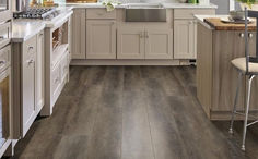 a kitchen with white cabinets and wood floors