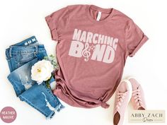 It's Marching Band Season! This trendy retro style marching band shirt is printed on Bella and Canvas brand shirts for the ultimate in comfort and style. More marching band (and music) shirt designs are available at our shop's homepage. https://www.etsy.com/shop/AbbyZachDesigns ----HOW OUR SHIRTS ARE MADE ----  * We use the process of DTG, which stands for direct to garment printing. We partner with a professional printer who applies ink directly into the shirt. (We do not use vinyl.) This gives Marching Band Sister Shirts Ideas, Marching Band Shirts Parents, Flute Section Shirts Marching Bands, Band Mom Shirts Ideas Percussion, Marching Band Section Shirts, Music Shirt Design, Marching Band Shirts, Band Shirts, Marching Band