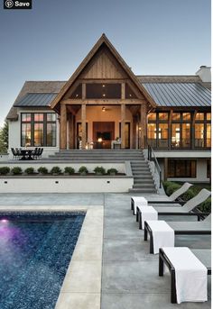 a house with a pool in front of it and stairs leading up to the porch