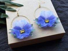 Exquisite Blue Silk Pansy Hoop Earrings, the perfect accessory to add a touch of elegance and femininity to any outfit. Inspired by the beauty of spring flowers, these earrings are crafted with delicate silk petals in shades of blue that perfectly mimic the charming pansy blooms. Designed to be versatile and timeless, these earrings come in a classic hoop shape that's perfect for any occasion. Whether you're looking to add a pop of color to your everyday wardrobe or searching for something blue Elegant Flower Hoop Earrings For Summer, Elegant Summer Flower Earrings For Gift, Elegant Summer Flower Earrings As Gift, Elegant Summer Gift Flower Earrings, Chic Handmade Flower Earrings For Gifts, Chic Handmade Flower Earrings As A Gift, Elegant Hoop Earrings For Summer Wedding, Elegant Summer Wedding Hoop Earrings, Blue Flower Earrings For Spring Parties