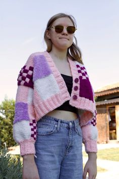 a woman wearing sunglasses and a pink sweater