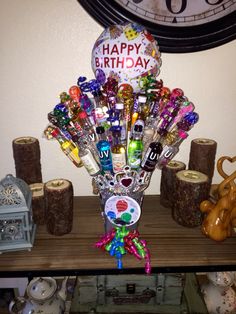 a vase filled with lots of candy on top of a wooden table next to a clock