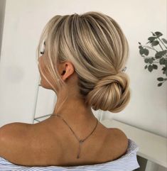 a woman with blonde hair styled into a low bun