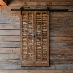 an old wooden window with shutters on the side of a building that is made out of wood planks