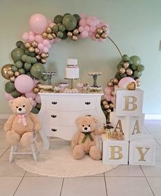 two teddy bears are sitting in front of a baby's first birthday cake table