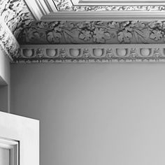 a white door and window in a room with decorative moldings on the ceiling above it