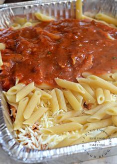 a pan filled with pasta and sauce on top of a table