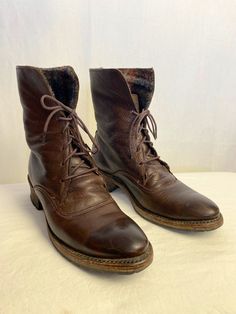 "These are a nice rendition of a true vintage style boot. Lace up style ankle boots, with a plaid wool lining, which you can turn down if you like. See photos.  In very good condition, lots of wear left in these babies! A dark oiled looking leather. Grey, orange brown plaid inside. Nice stacked style wooden heels. Similar quality to an uggh or frye boot. Made in the USA by Vintage brand shoes/boots.  They show a little wear on the very bottoms. There's a few light surface scratches on the toe & Fall Rugged Combat Boots With Leather Footbed, Rugged Fall Combat Boots With Leather Footbed, Rugged Combat Boots With Leather Footbed For Fall, Rugged Ankle Combat Boots For Winter, Rugged Winter Ankle Combat Boots, Rugged Ankle-high Martin Boots For Winter, Rugged Work Boots With Round Toe For Winter, Rugged Winter Ankle Work Boots, Rugged Winter Work Boots With Round Toe