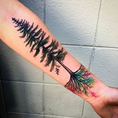 the tattoo artist is showing off his arm with an arrow and pine tree on it