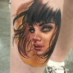 a woman's leg with a tattoo on it that has an image of her face and hair