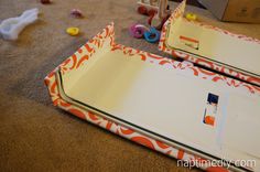 two empty trays sitting on the floor next to some scissors and other crafting supplies