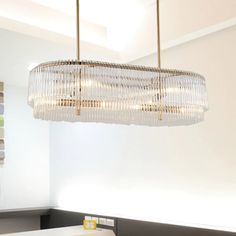 a chandelier hanging from the ceiling in a room with white walls and furniture