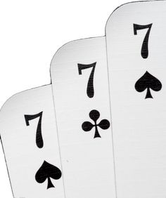 four playing cards with the number seven on each card in black and white, set against a white background