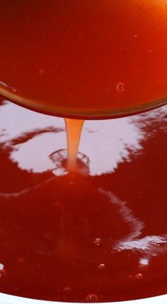 a spoon full of liquid being poured into a bowl