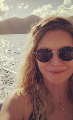 a woman wearing sunglasses on a boat in the ocean