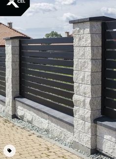 a black and white photo of a fence with stone pillars on the sides, along with a brick walkway