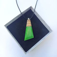 Introducing a Zebrano Wood Pendant with Vibrant Green Resin, a stylish necklace for everyday wear. This exclusive hand-polished trapeze-shaped pendant combines the rustic charm of zebrano wood with vibrant green epoxy resin. The distinctive stripes of the Central American Zebrano wood dance through the design, reminiscent of the wild beauty of a zebra's mane, while the vibrant green-turquoise epoxy resin adds a splash of mesmerizing color, akin to a hidden tropical lagoon. The geometric pendant Modern Green Necklace As Gift, Modern Green Necklace As A Gift, Modern Green Necklace For Gift, Tropical Lagoon, Necklace For Everyday, Vert Turquoise, Wild Beauty, Central American, Stylish Necklace