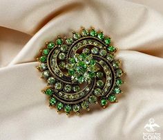 ..................................Weight: 37.7 gramsMeasurements: 2.30" Diameter; 0.70" DeepStone: Green Rhinestone*This vintage Fashion Jewelry brooch features bright and glittering yellow & green rhinestones with gold tone, floral wreath-like design. This brooch is in great condition, with little to no wear and patina. The clasp works nicely. This stunning brooch would make an excellent gift for a loved one.. or better yet, an oh-so-delicious treat for yourself! Add spark to your outfit wi Green Jeweled Brooch For Gift, Green Jeweled Brooches As Gift, Green Brooch For Party, Formal Green Rhinestone Brooches, Green Costume Jewelry Brooches For Gifting, Green Costume Jewelry Brooches For Gift, Green Brooch Jewelry For Evening, Green Rhinestone Wedding Brooch, Green Rhinestone Wedding Brooches