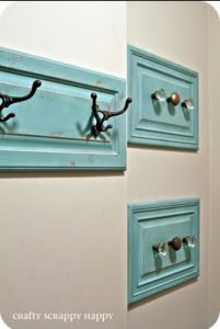 two blue door knobs are attached to the side of a wall with hooks on them