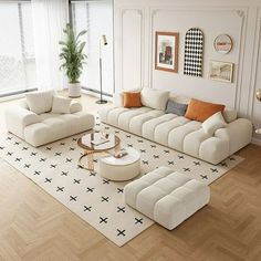 a living room with white furniture and wood flooring in front of a large window