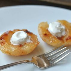 two small pastries on a white plate with a fork