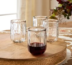 four glasses are sitting on top of a table