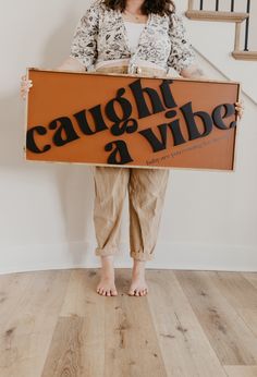 a woman holding a sign that says caught and vibe